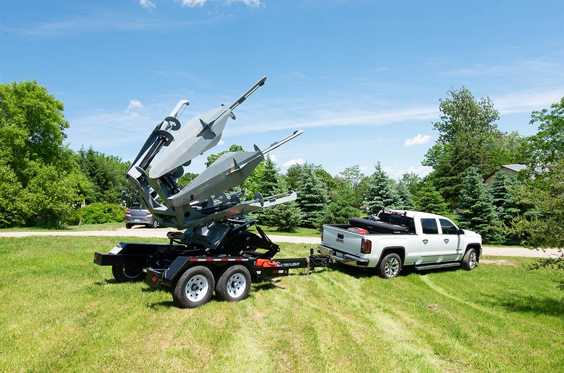 Baumalight TR650 trailer tree spade behind a pickup truck; model reference photo, pictured powerpack excluded