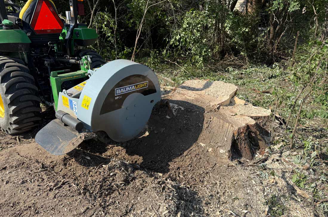 Baumalight 1P34 stump grinder working across a large stump behind a tractor