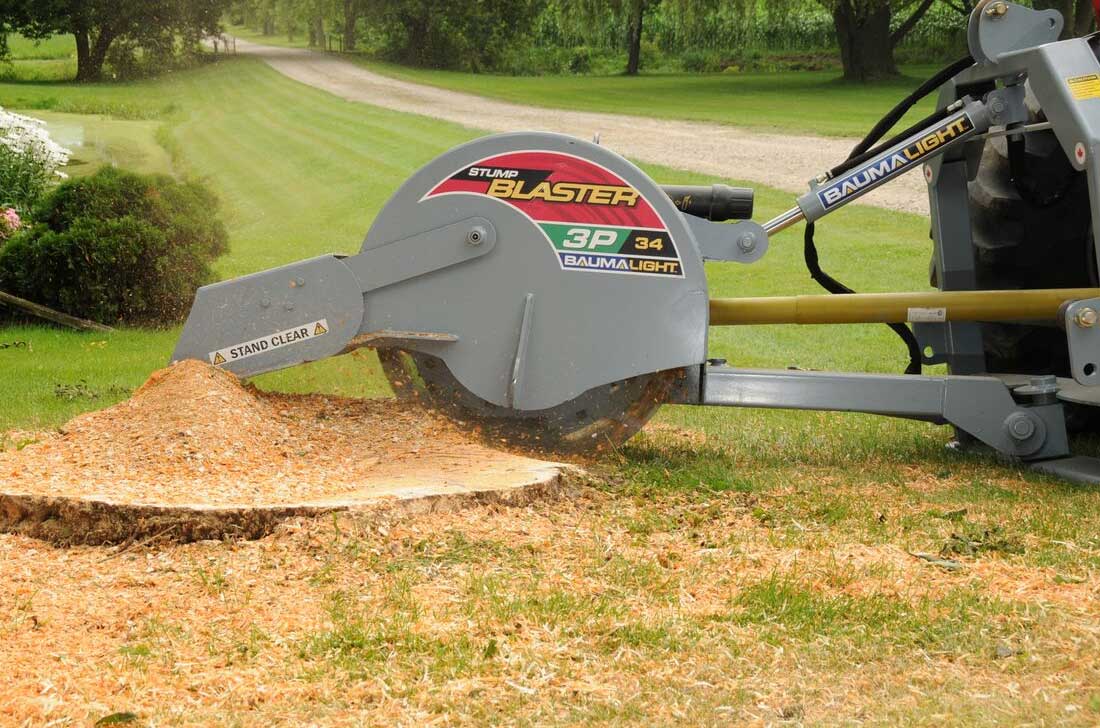 Baumalight 3P34 tractor stump grinder working beside a pile of wood chips