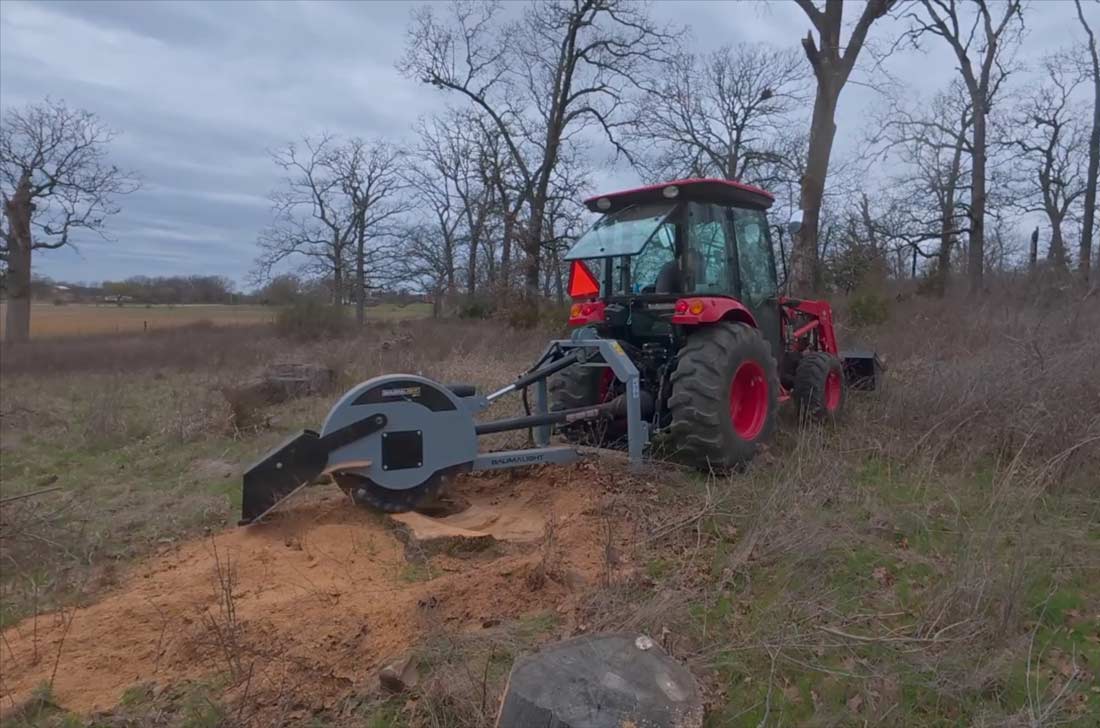 Opposite-side view of the Baumalight 3P38 stump grinder working behind a tractor