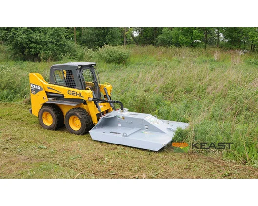 Baumalight CF372 brush cutter mounted on a skid steer beside tall grass