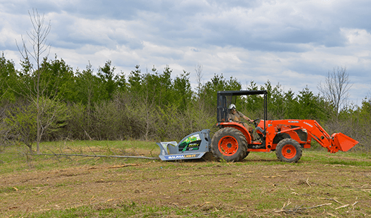 Baumalight CP560 and tractor beside a cleared brush area