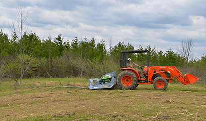 Baumalight CP560 and tractor beside a cleared brush area